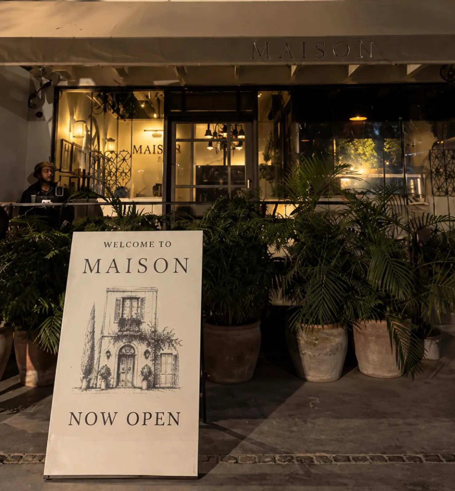 Maison's Welcome / Now Open sign at the entrance